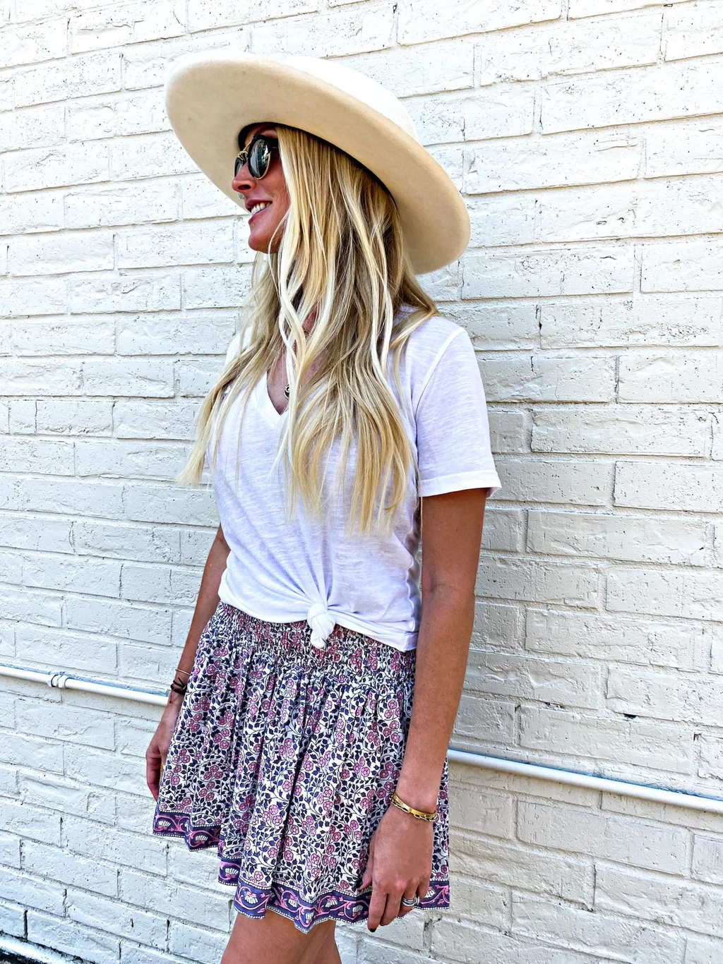 Cowboy hat, white ruched blouse, pink miniskirt