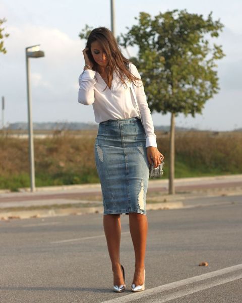 Dressed in a white button-down shirt, a denim knee-length skirt, a beige bag, and heel.Dressed in a white button-down shirt, a denim knee-length skirt, a beige bag, and heel.