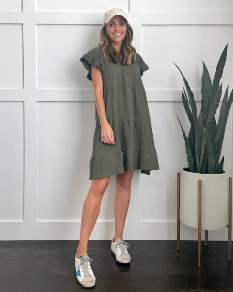 Wearing a ruffled minidress in olive green and gray lace-up shoes