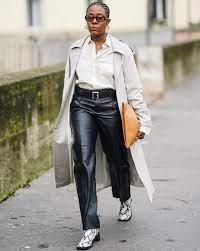 Wearing a white button-down shirt, black leather skinny pants, a brown leather bag, and white flats.